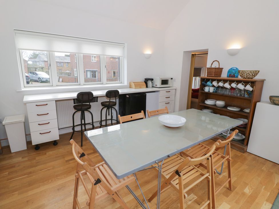A kitchen with a dining table and stools at Ambercote in Priors Marston near Southam