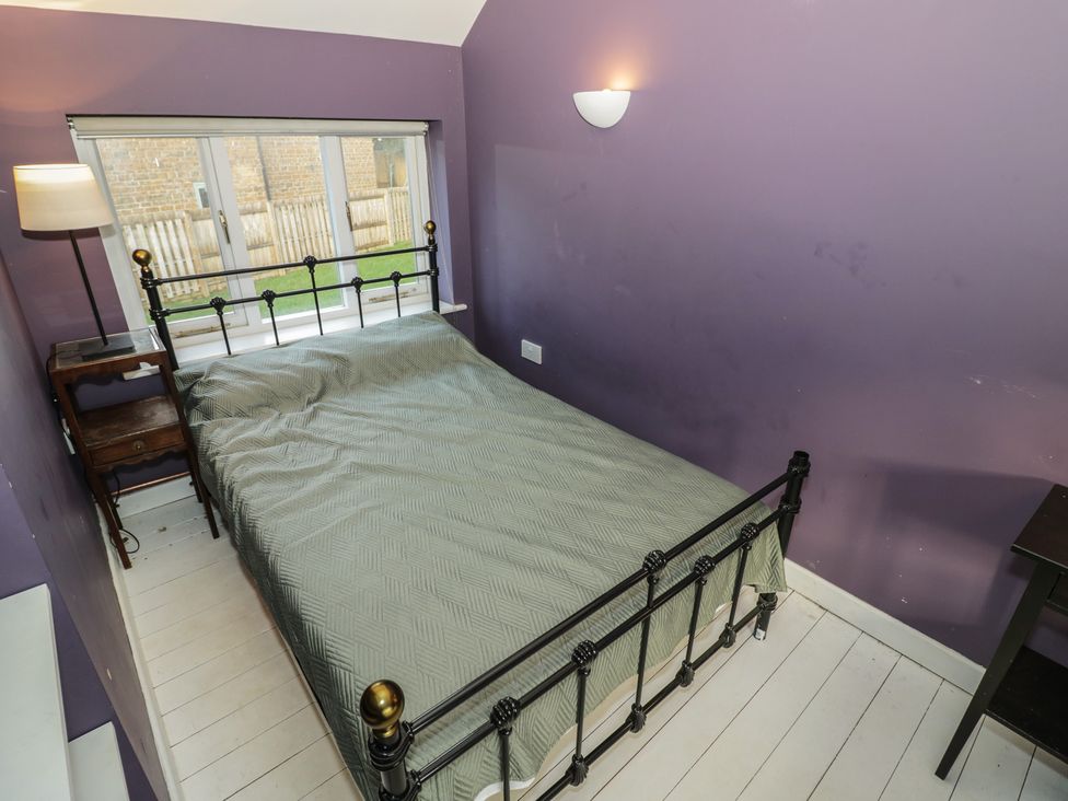 A bedroom with a bed, nightstand, and window at Ambercote Priors Marston near Southam