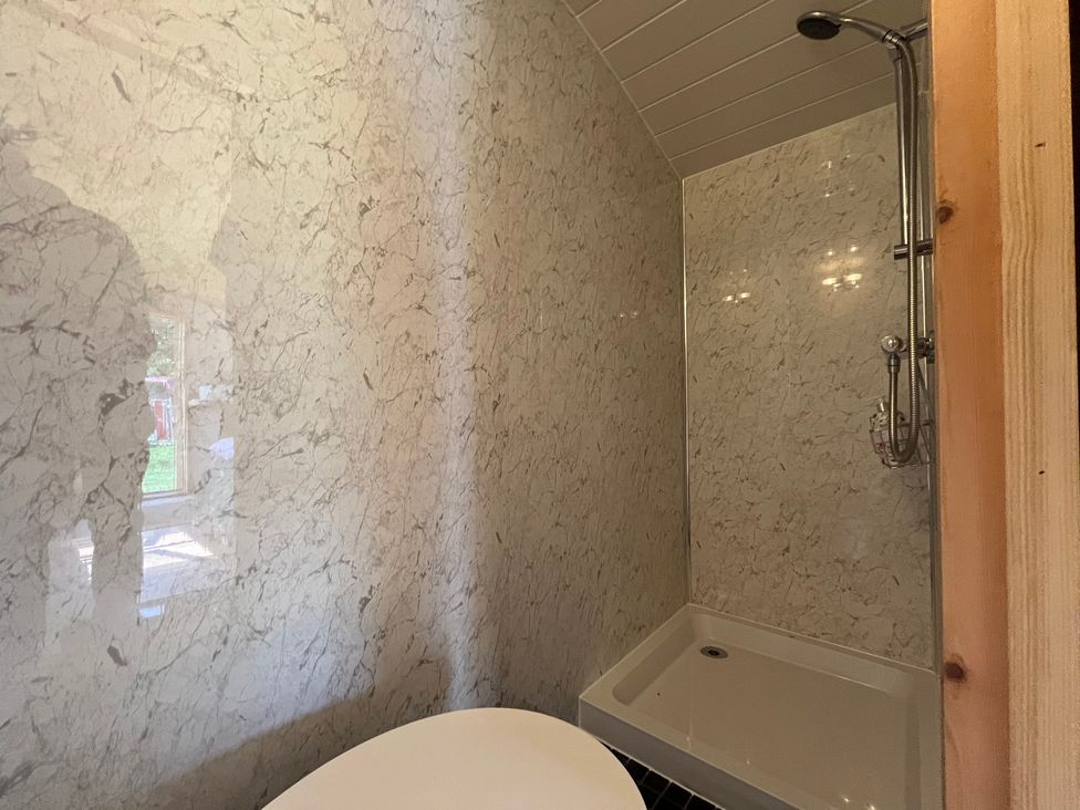 A bathroom with a shower and bathtub at Shepherd Hut in Gloucester