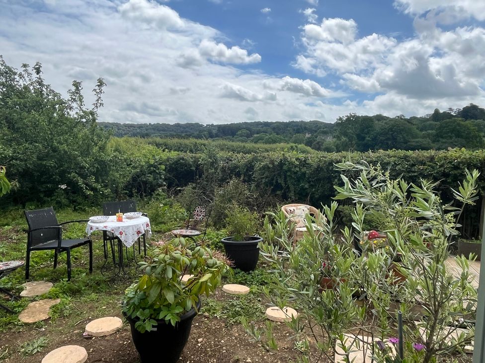 A garden with a table and chairs at Shepherd Hut Gloucester