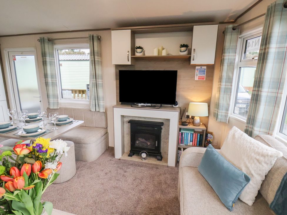 A living room with a sofa and television at Pepper Pot Lodge in Knaresborough