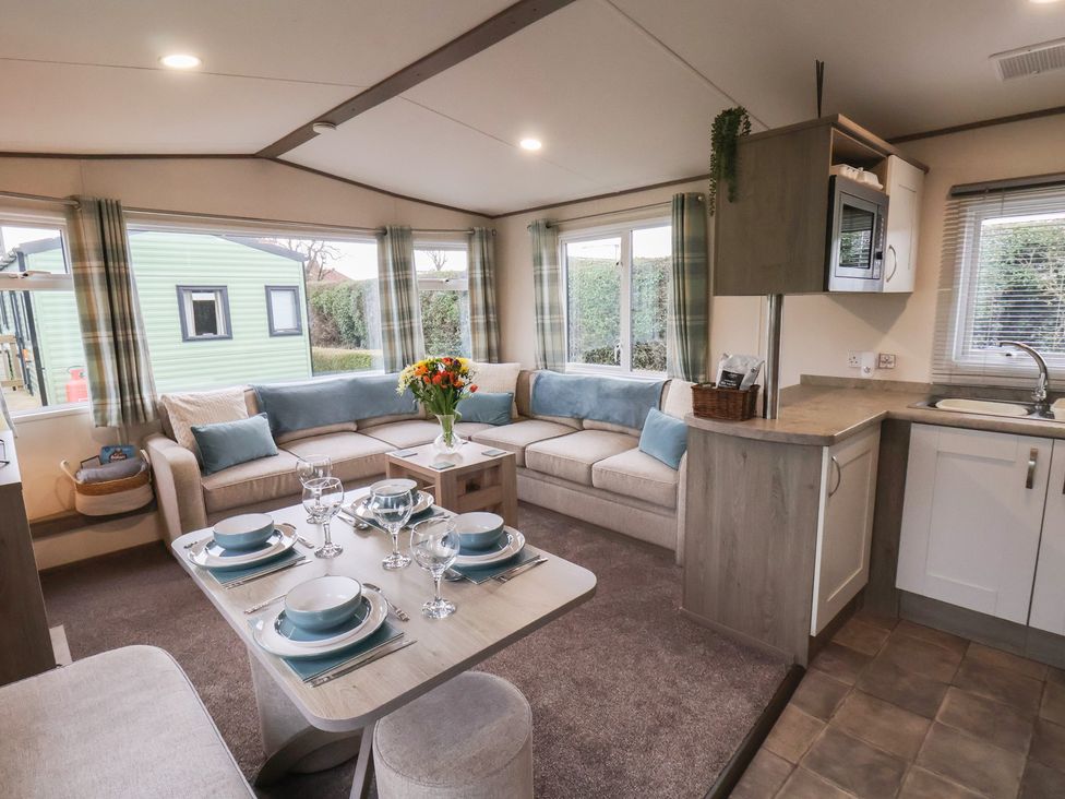 A living room with a sofa and dining area at Pepper Pot Lodge in Knaresborough