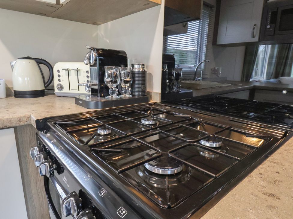 A kitchen with a gas stove and various appliances at Pepper Pot Lodge in Knaresborough