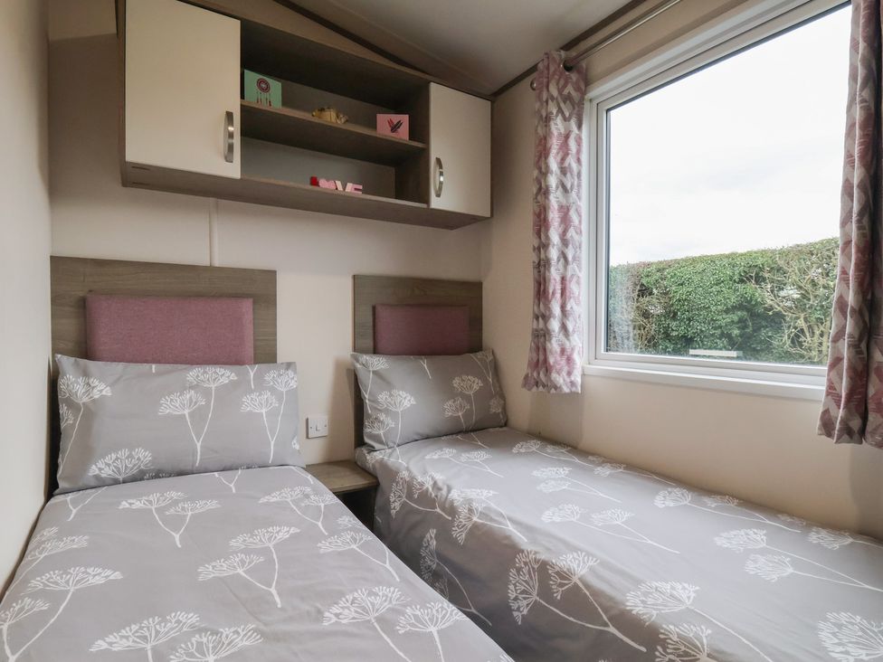 A bedroom with twin beds and a window at Pepper Pot Lodge in Knaresborough