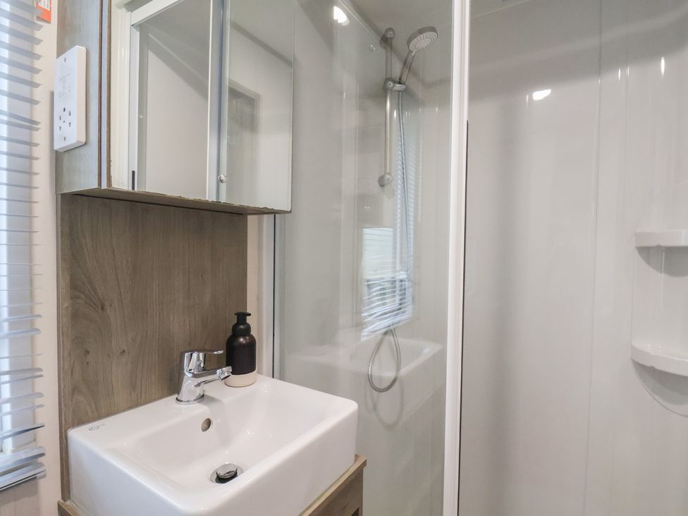 A bathroom with a sink and shower at Pepper Pot Lodge in Knaresborough