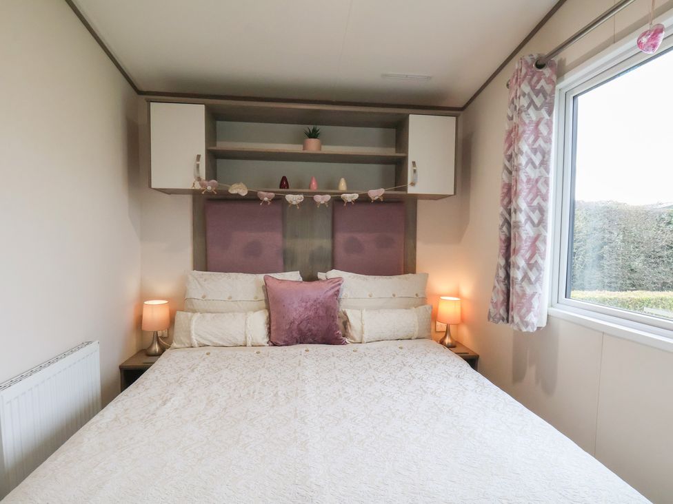A bedroom with a bed and lamps at Pepper Pot Lodge in Knaresborough