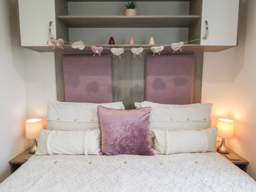 A bedroom with a bed and bedside lamps at Pepper Pot Lodge in Knaresborough