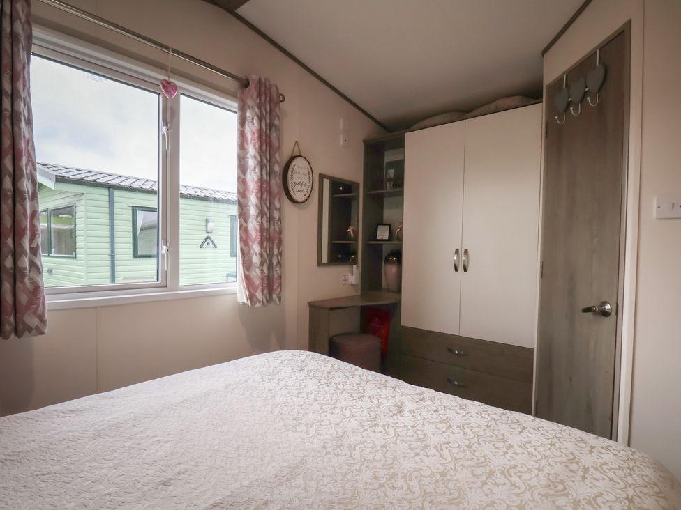 A bedroom with a bed and wardrobe at Pepper Pot Lodge in Knaresborough