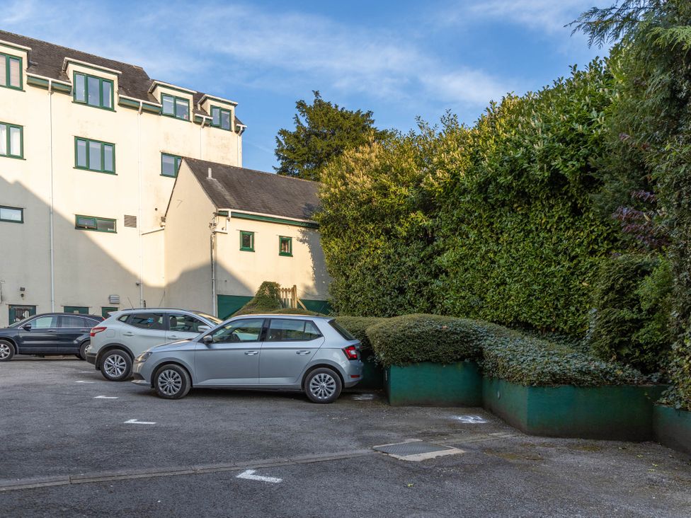 A parking lot with cars and greenery at Luxury 2 Bed Room Lake View Apt Bowness Parking Bowness-On-Windermere