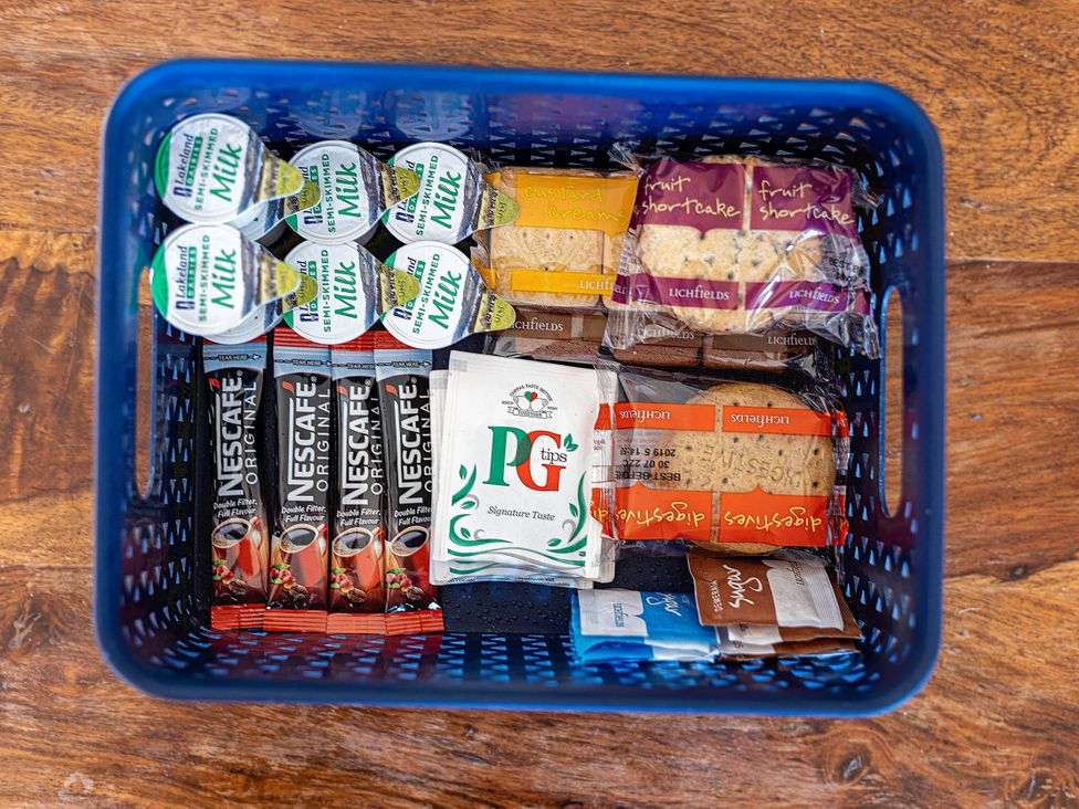 A basket containing milk, coffee, tea, and various baked goods at Luxury 2 Bed Room Lake View Apt Bowness Parking Bowness-On-Windermere