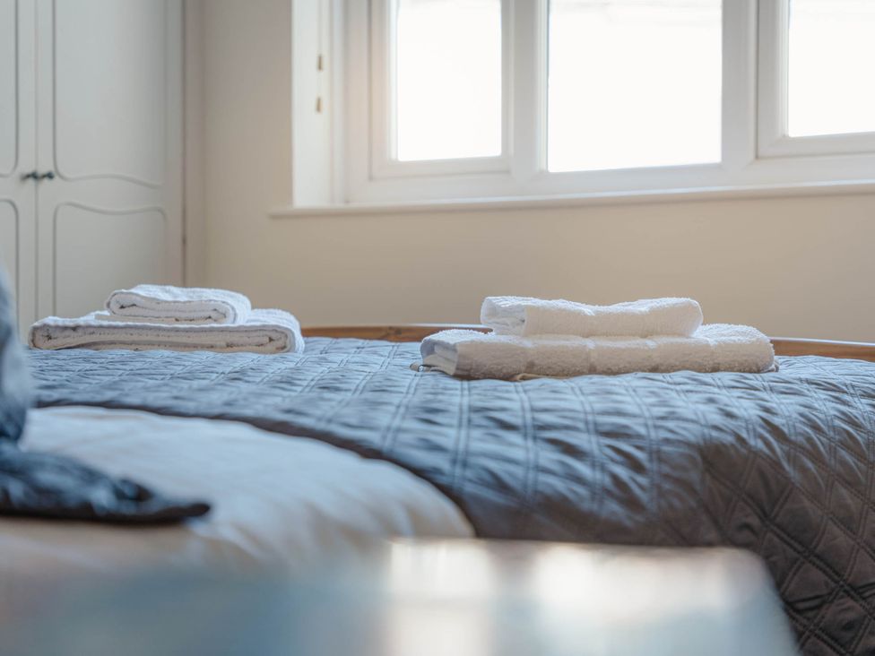 A bedroom with towels folded on the bed at Luxury 2 Bed Room Lake View Apt Bowness Parking Bowness-On-Windermere