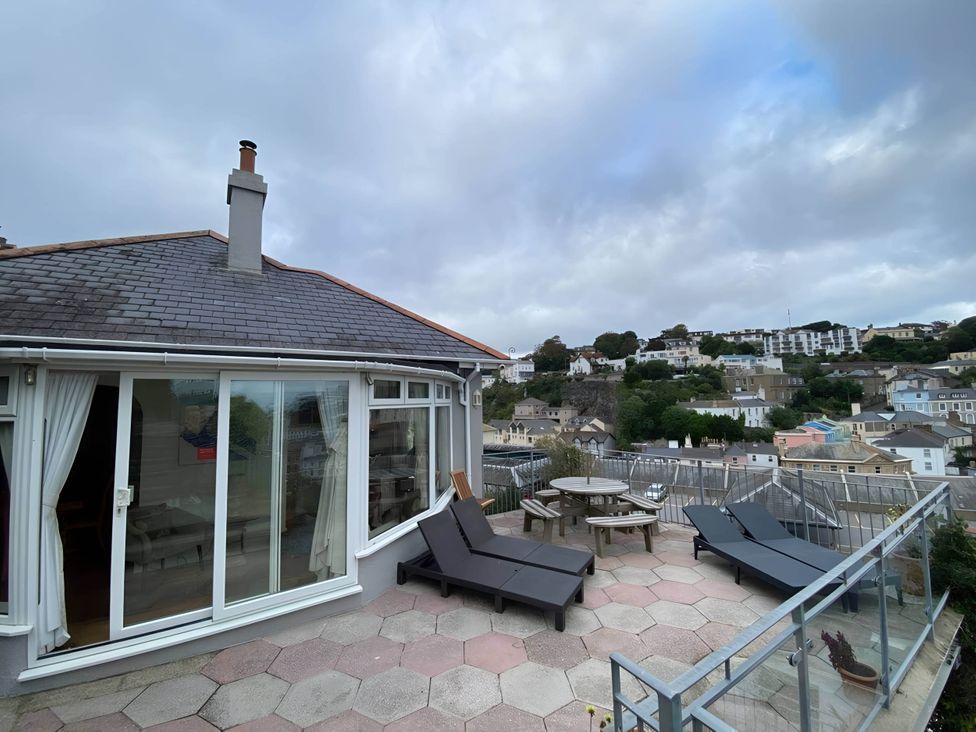 An outdoor area with deck chairs and a table at 4 Bed House-Sleeps 8-Parking-Pets-MarinaSeaView in Torquay
