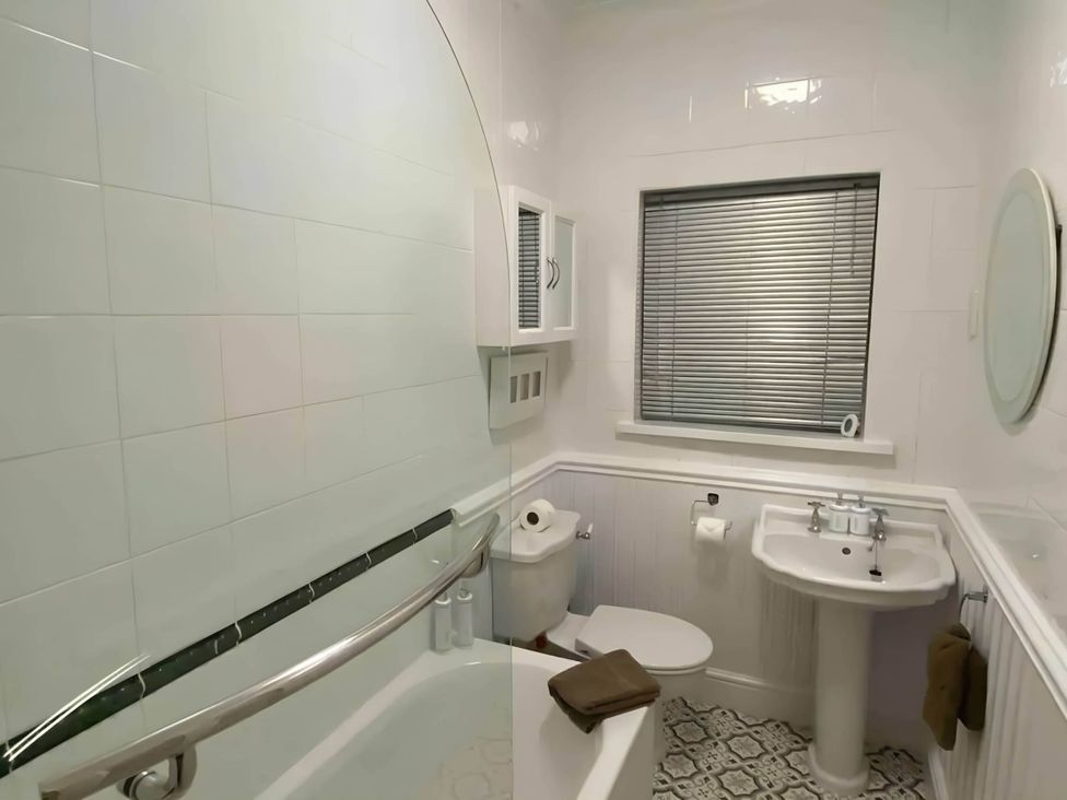 A bathroom featuring a bathtub, toilet, sink, and window at 4 Bed House-Sleeps 8-Parking-Pets-MarinaSeaView in Torquay
