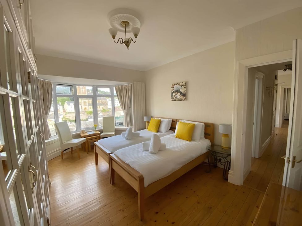A bedroom with two single beds and a table at 4 Bed House-Sleeps 8-Parking-Pets-MarinaSeaView in Torquay