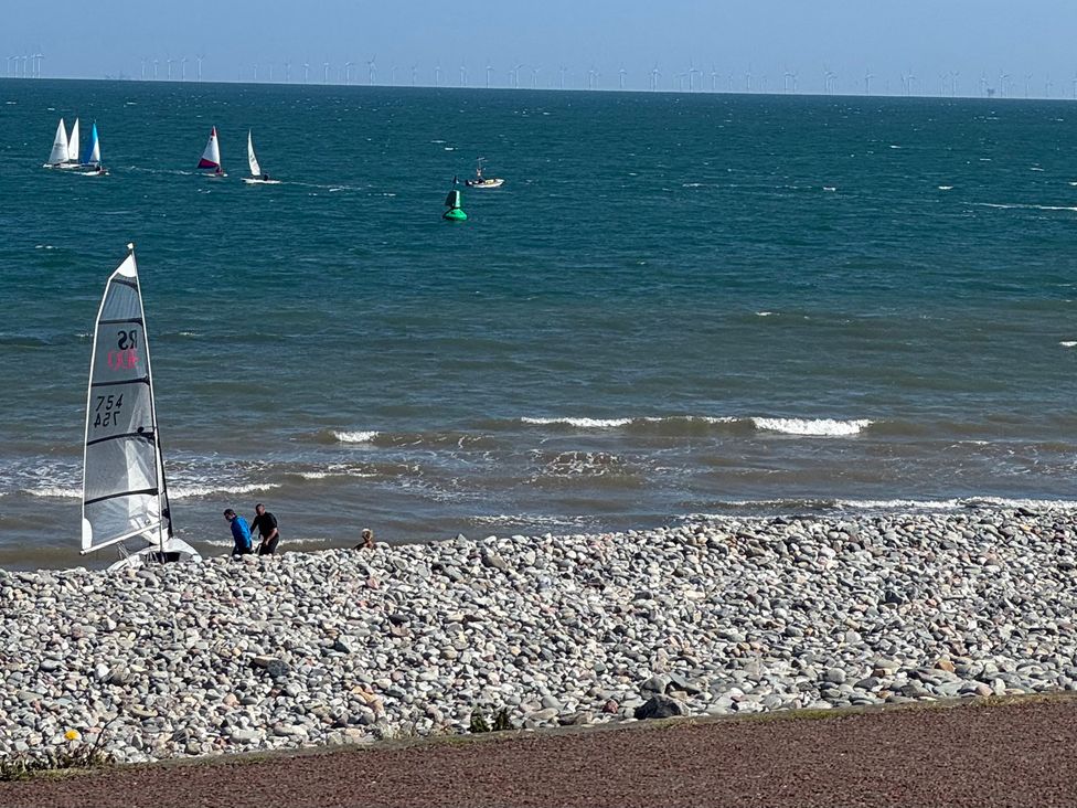 People near a sailing boat on a beach by the ocean at Sea View, East Parade Llandudno