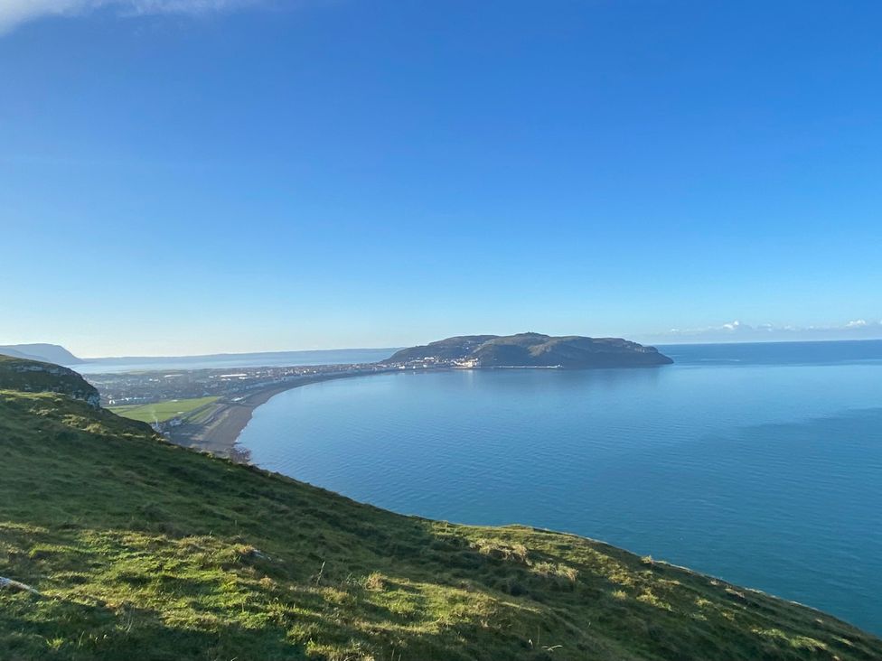 A coastline view with hills and water at Sea View, East Parade in Llandudno