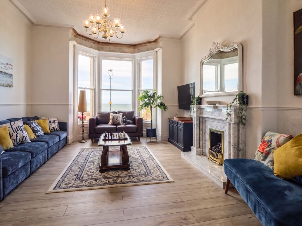 A living room with a table and sofa at Sea View, East Parade in Llandudno