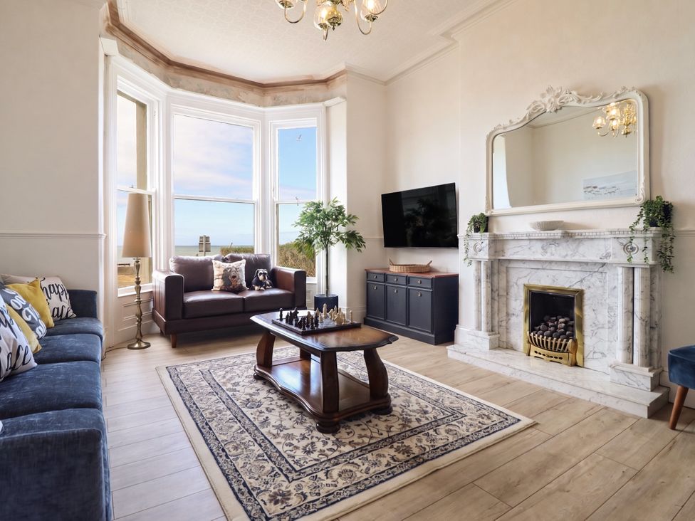 A living room with a television and seating at Sea View, East Parade Llandudno