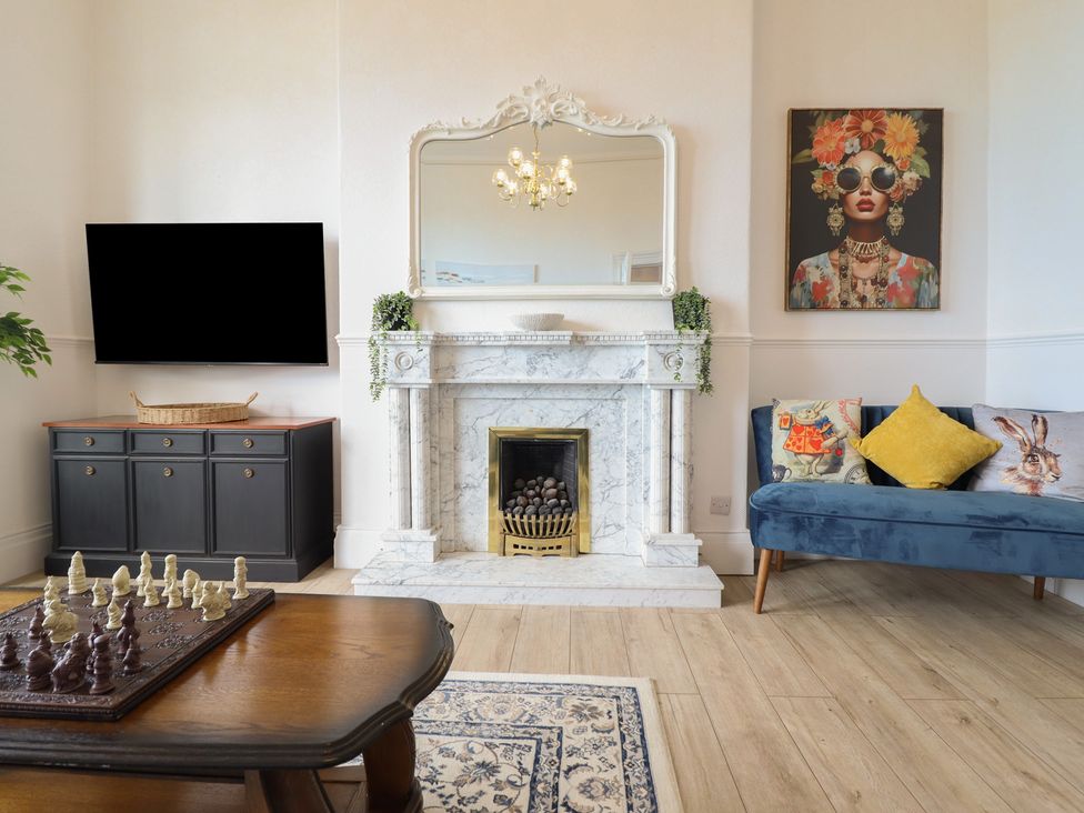 A living room with a fireplace and television at Sea View, East Parade in Llandudno