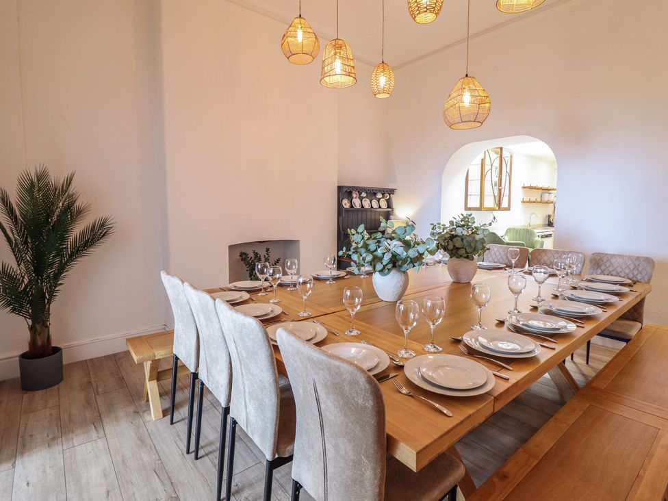 A dining room with a large table and chairs at Sea View, East Parade in Llandudno