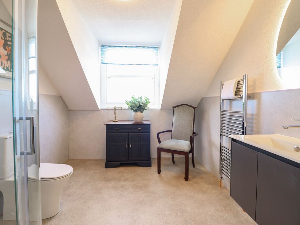 A bathroom with a sink, toilet, and vanity at Sea View, East Parade, Llandudno