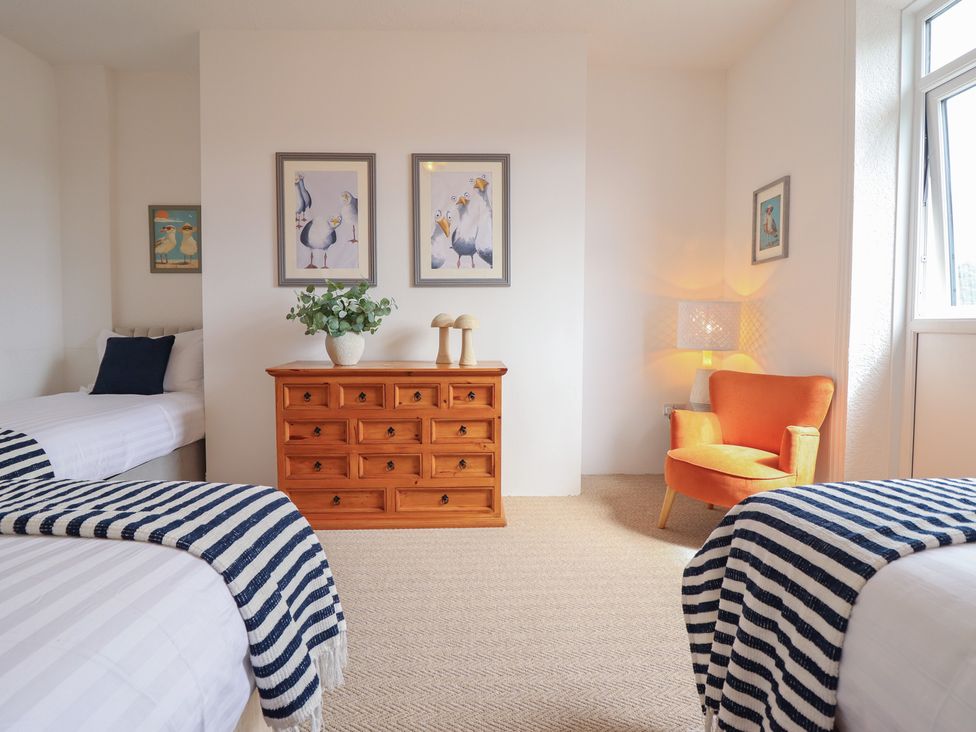 A bedroom with two beds and a dresser at Sea View, East Parade in Llandudno