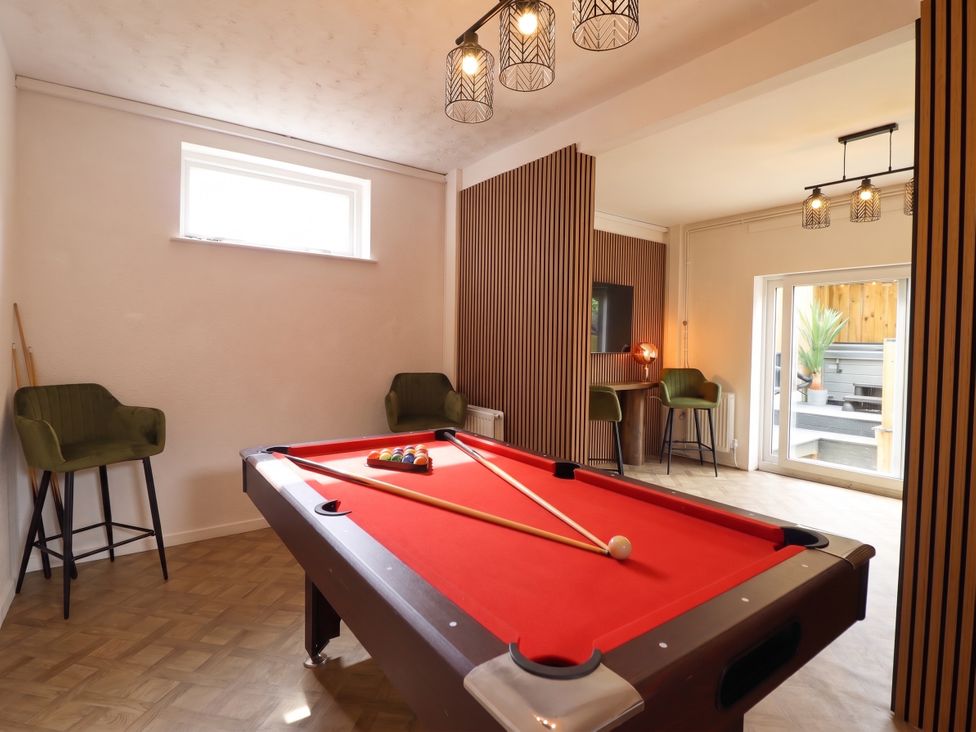 A game room with a pool table and chairs at Sea View, East Parade Llandudno