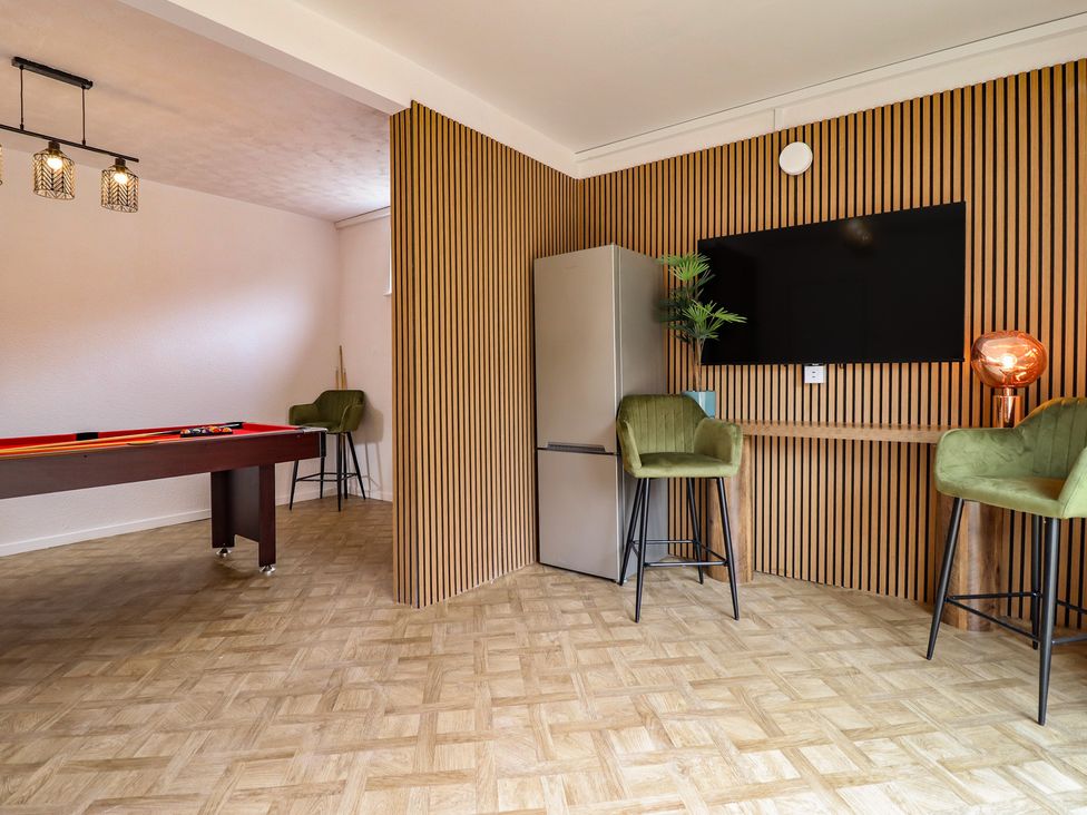 A game room with a pool table and refrigerator at Sea View, East Parade Llandudno