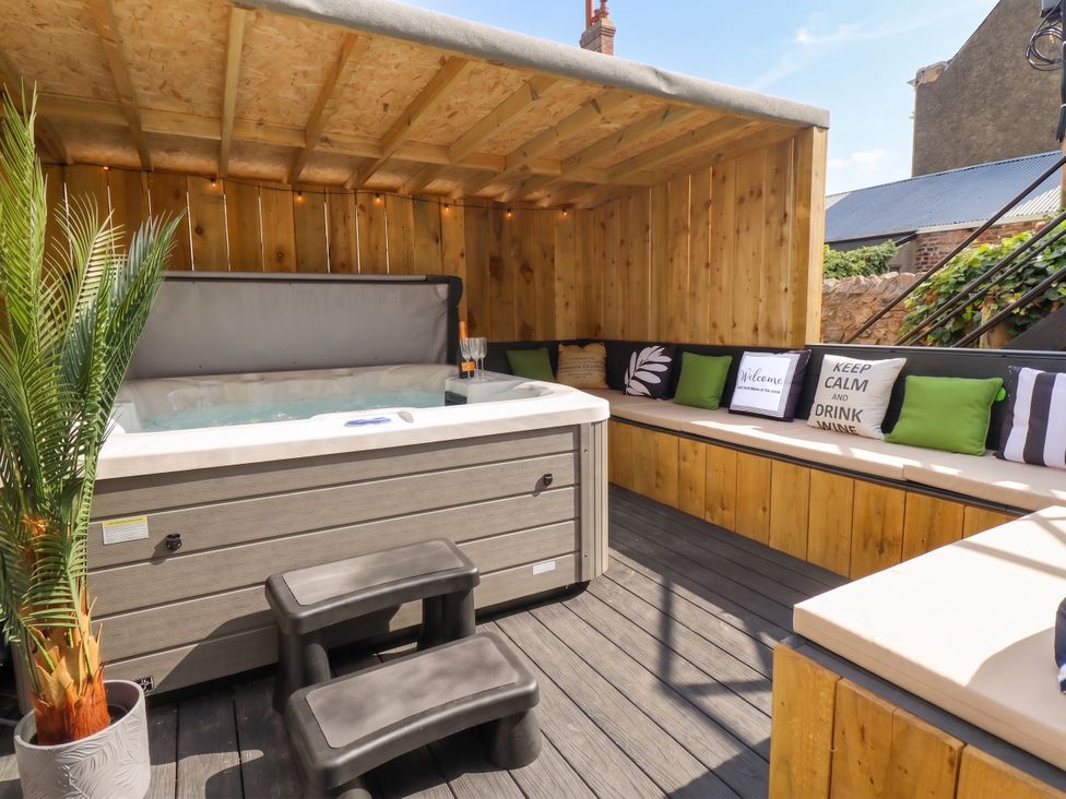 An outdoor area with a hot tub and seating at Sea View, East Parade, Llandudno