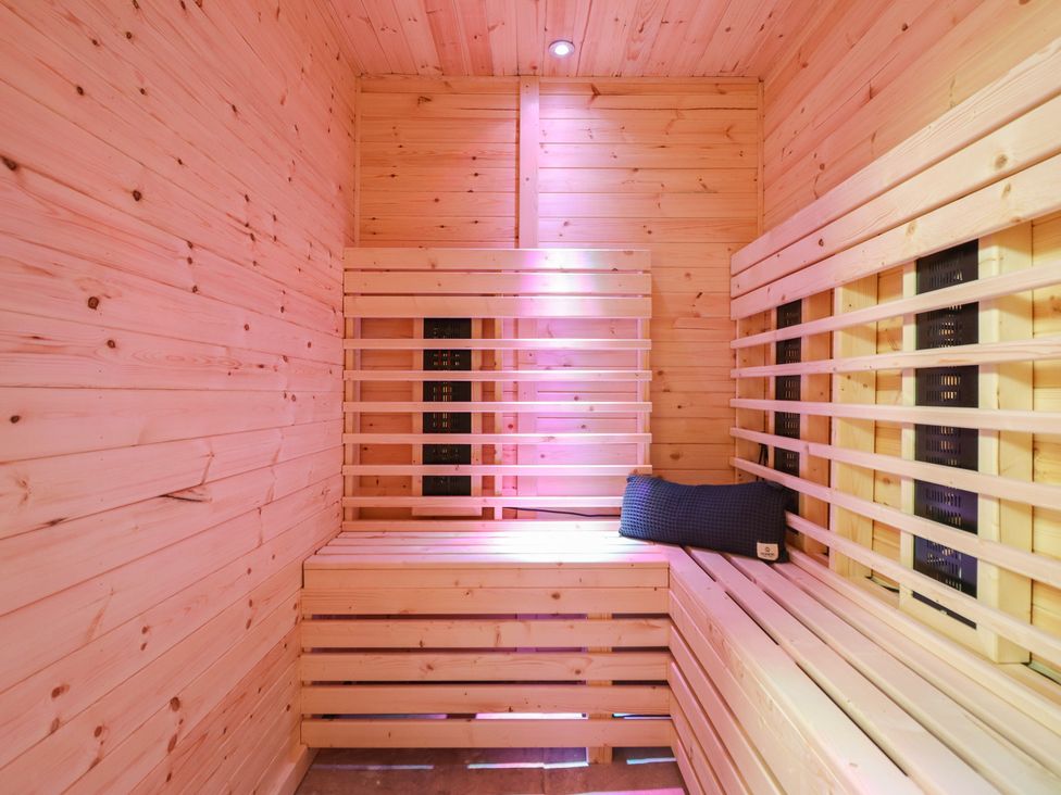 A sauna with wooden benches and a sauna heater at Sea View, East Parade, Llandudno