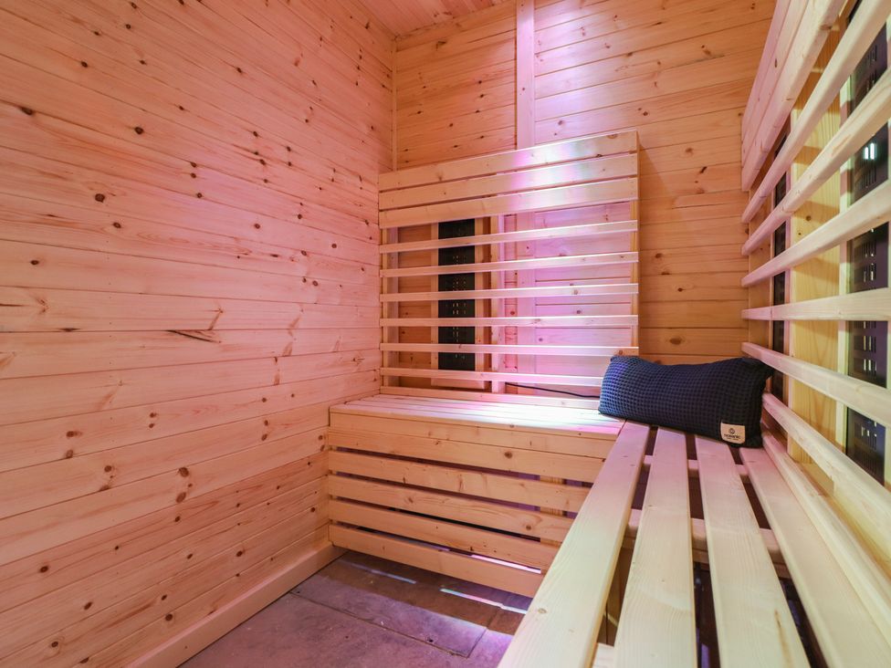 A sauna with wooden walls and benches at Sea View, East Parade Llandudno