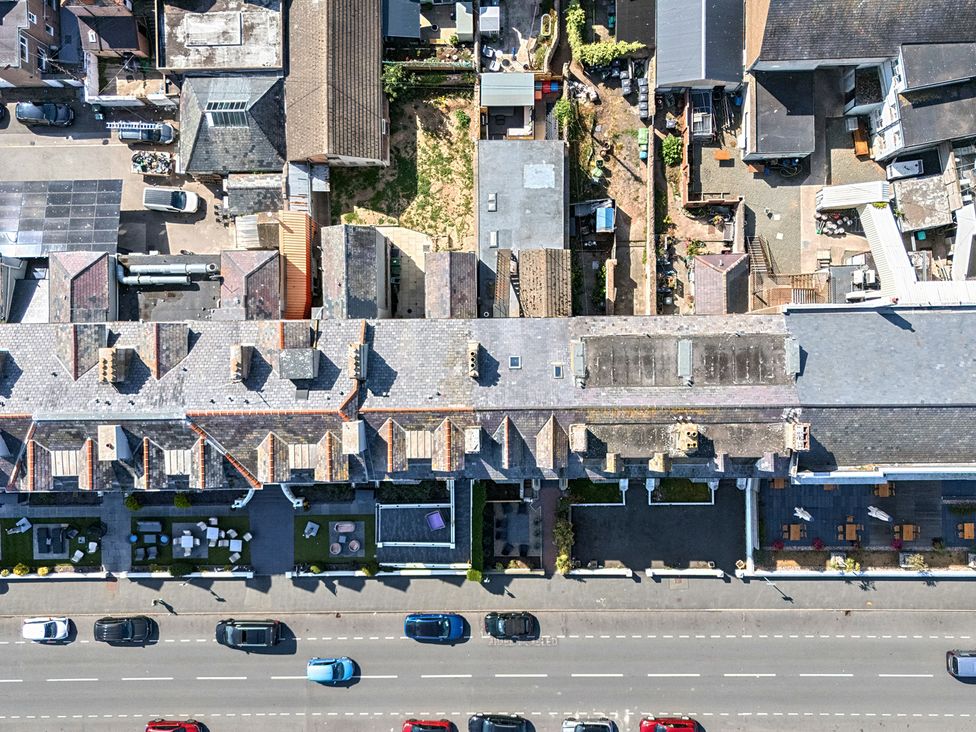 An outdoor area with rooftops, vehicles, and a garden at Sea View, East Parade in Llandudno