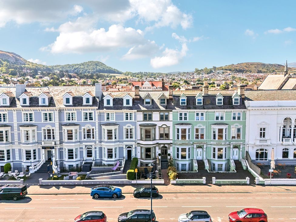 A row of houses with a road and cars at Sea View, East Parade Llandudno