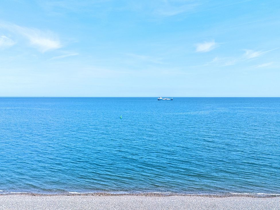 A view of the sea with a ship and a buoy at Sea View, East Parade Llandudno