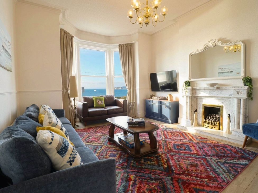 A living room with a fireplace and television at Sea View, East Parade, Llandudno