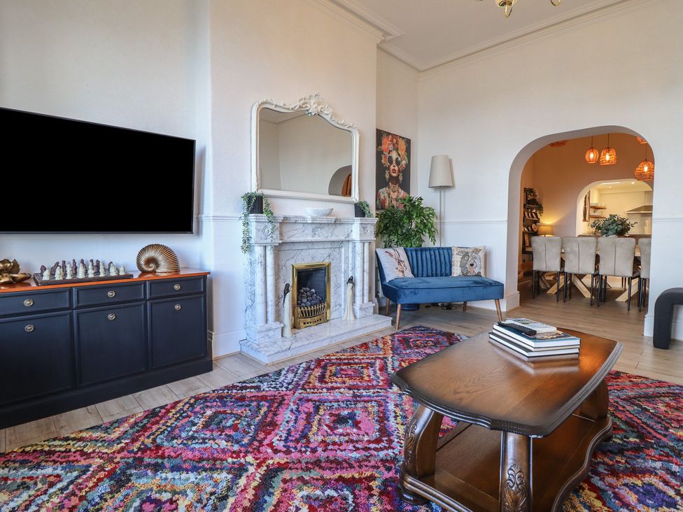 A living room with a fireplace and television at Sea View, East Parade in Llandudno