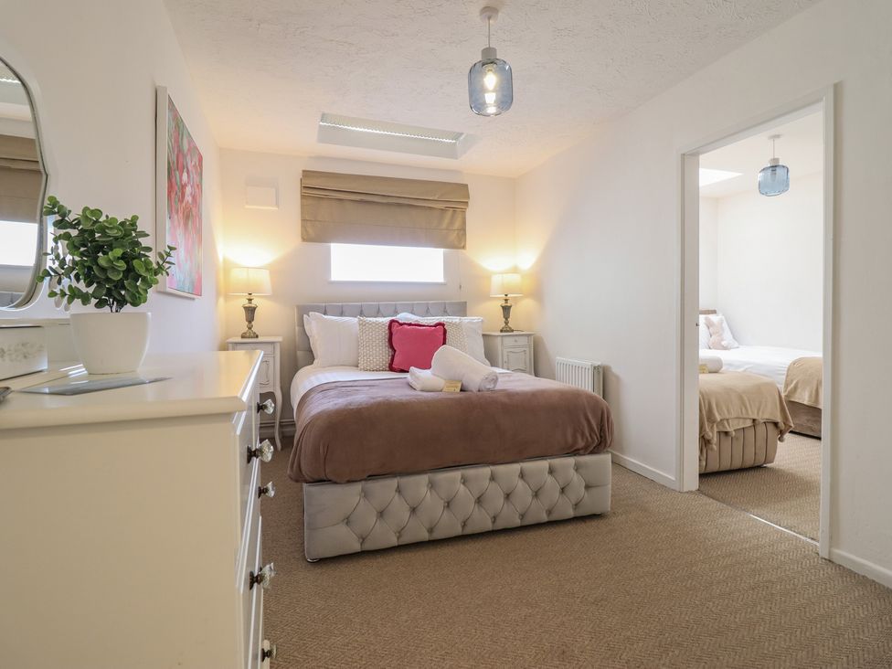 A bedroom with two beds and a dresser at Sea View, East Parade