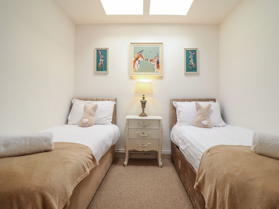 A bedroom with two single beds and a nightstand at Sea View, East Parade Llandudno