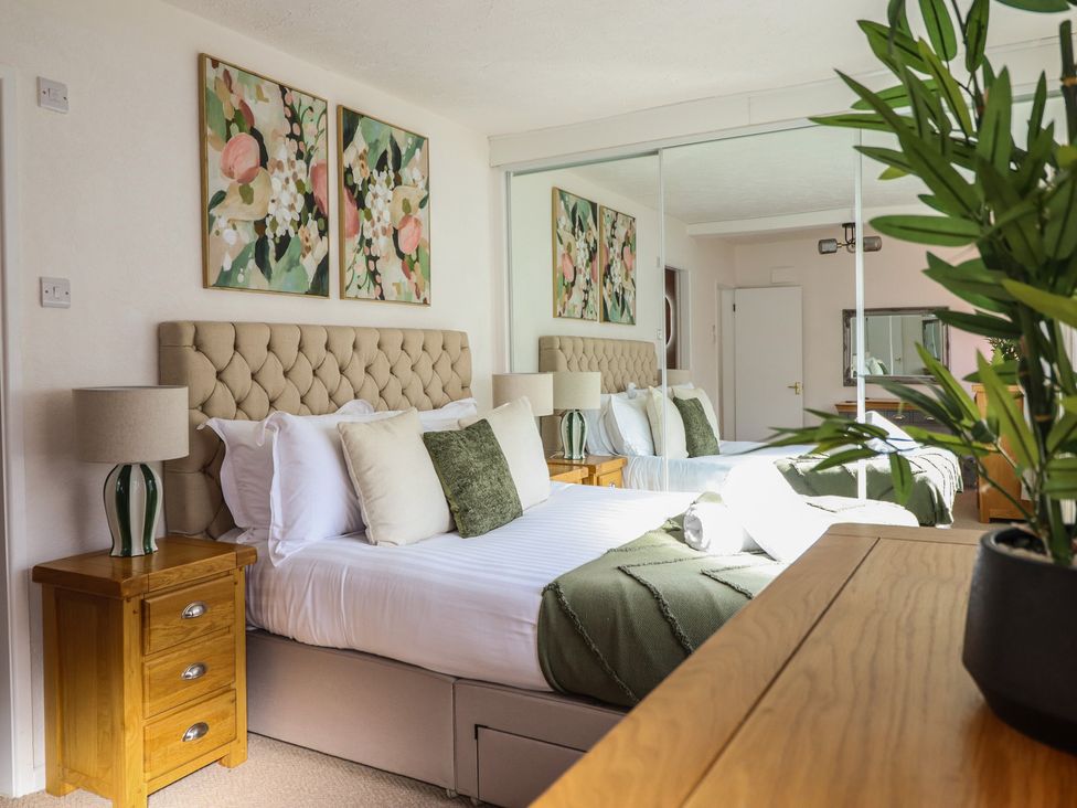 A bedroom with a bed and decorative pillows at Sea View, East Parade, Llandudno