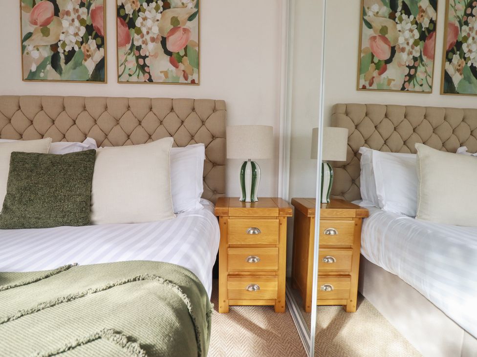 A bedroom with a bed and nightstands at Sea View, East Parade Llandudno