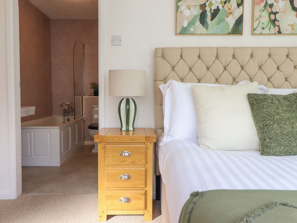 A bedroom with a bed and a bathroom visible at Sea View, East Parade in Llandudno