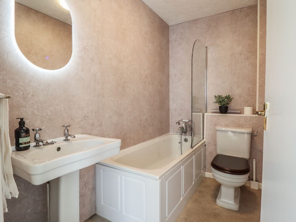 A bathroom with a bathtub, sink, and toilet at Sea View, East Parade in Llandudno