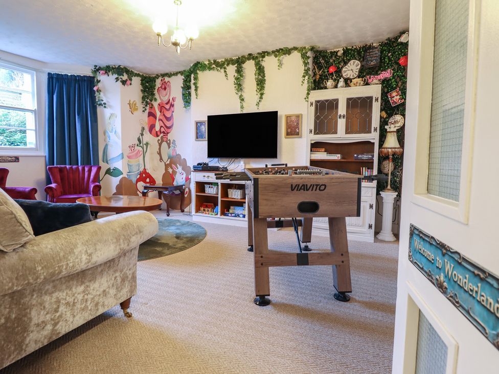 A living room with a foosball table and sofa at Sea View, East Parade, Llandudno