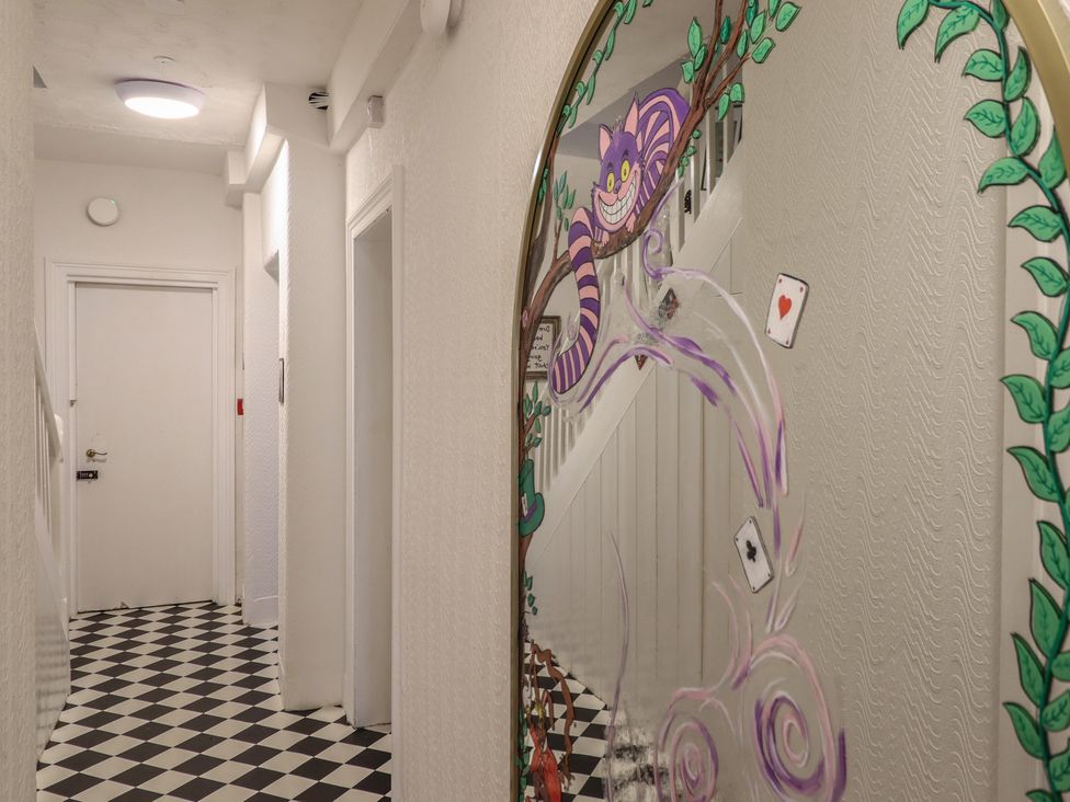 A hallway with a decorative mirror and checkered flooring at Sea View, East Parade in Llandudno