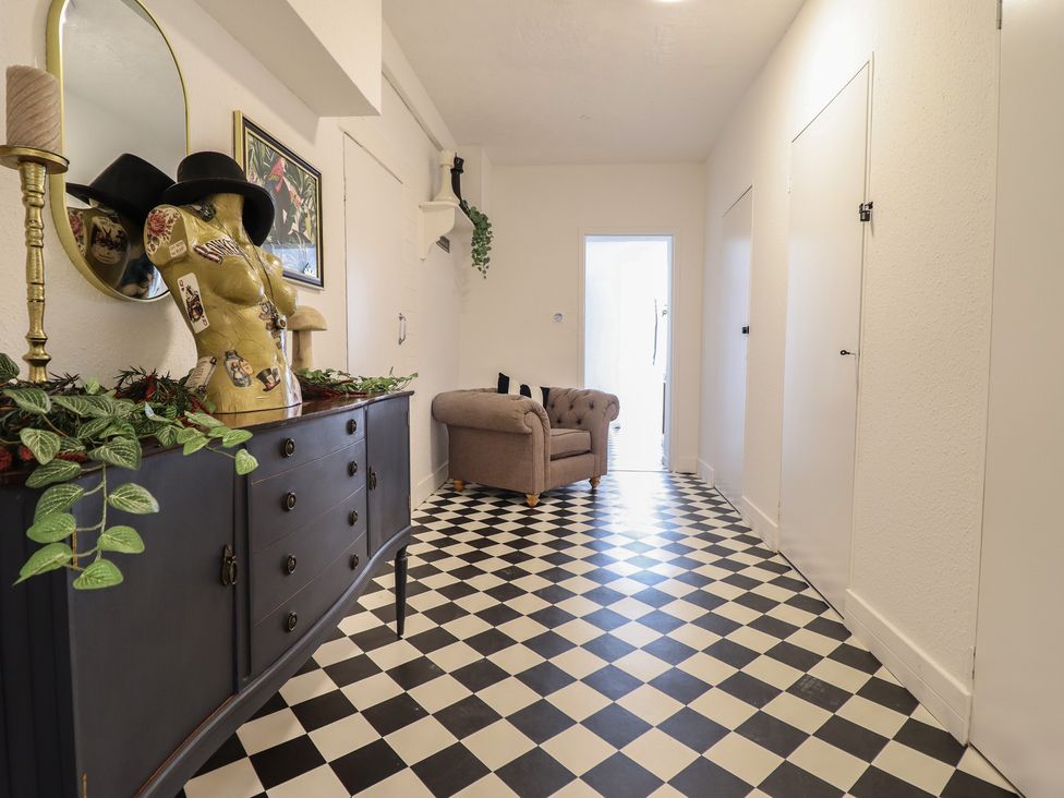A hallway with a mannequin and mirror at Sea View, East Parade in Llandudno