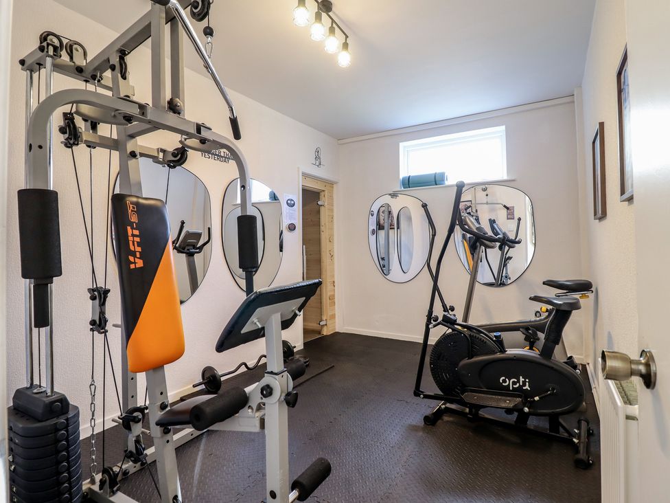 A gym with exercise equipment and mirrors at Sea View, East Parade in Llandudno