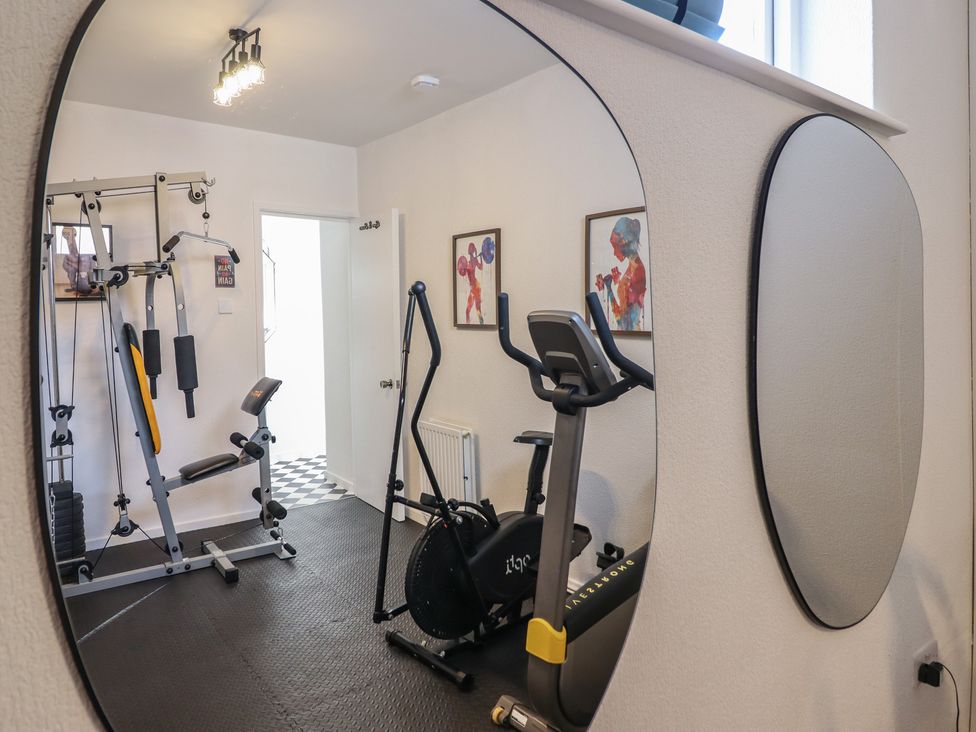 A home gym with fitness equipment and wall art at Sea View, East Parade in Llandudno