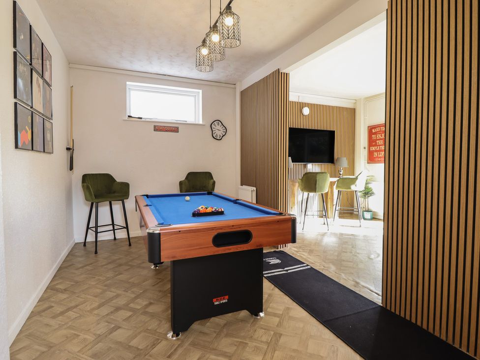 A game room with a pool table and bar stools at Sea View, East Parade Llandudno