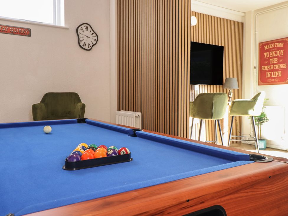 A recreation room with a pool table and seating area at Sea View, East Parade in Llandudno