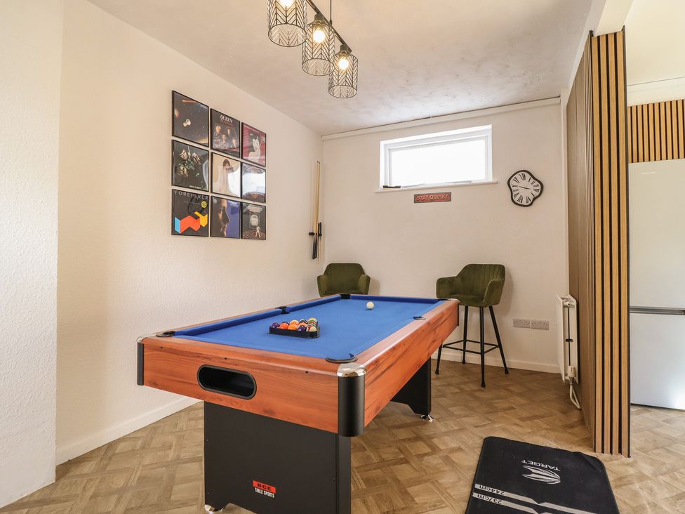 A game room with a pool table and bar stools at Sea View, East Parade in Llandudno